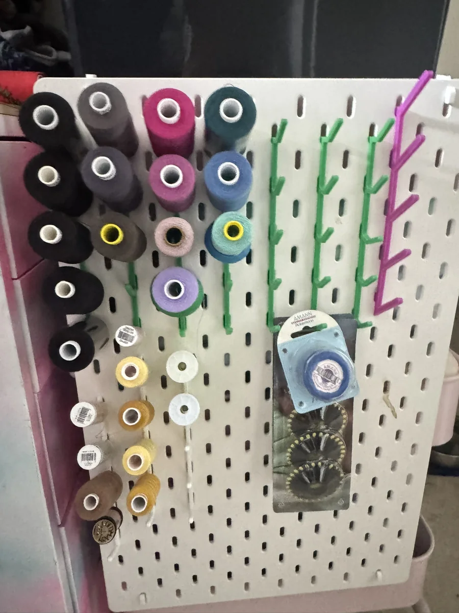 3D-gedruckte farbige Halter für Garnrollen an einer Lochwand